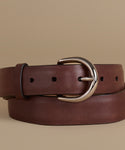 A dark brown leather belt with a polished silver-tone metal buckle, neatly coiled on a solid beige background.