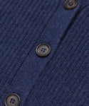 Close-up of the Cropped Cashmere Cocoon Cardigan in blue, showcasing its ribbed texture and dark buttons arranged vertically along the buttoned seam.