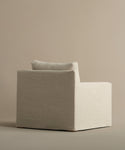The Harbor Chair, inspired by minimalist design, features a boxy shape, wide seat, and single back cushion in light beige Drift Linen upholstery, shown against a neutral backdrop.