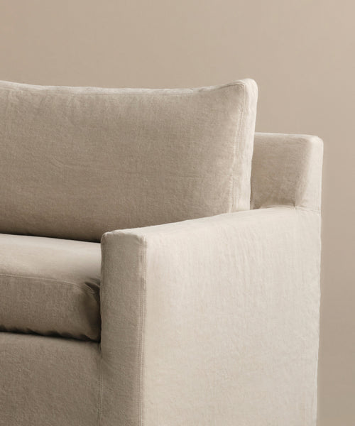 Close-up of the Harbor Sofa, handmade in Los Angeles with light beige linen upholstery. This sofa features clean lines and plush cushions, set against a neutral backdrop.