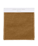 A Fabric Swatch Pine Linen in brown with white edge stitching, labeled jenni kayne home and Pine Linen on a white card at the top.