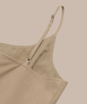 Close-up of the Rove Dress in khaki, featuring spaghetti straps and adjustable ties. Set against a beige background, its smooth matte fabric makes it the perfect choice for spring.