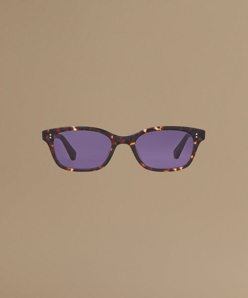 Tortoise sunglasses against a beige background.