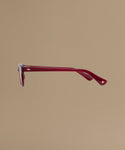 Red sunglasses against a beige background.