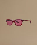 Red sunglasses against a beige background.