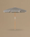 Black and white striped beach umbrella on a beige background