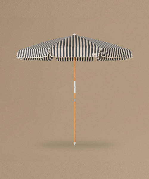 Black and white striped beach umbrella on a beige background