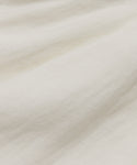 Close-up of the Annabel Skirt shows its white linen fabric with subtle wrinkles, visible threads, and gentle folds for a soft, smooth texture—ideal for achieving a vintage-inspired spring and summer look.