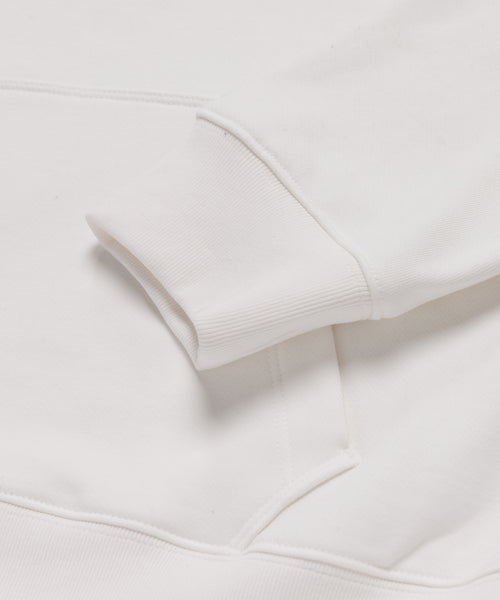 Close-up of the Bay Hoodie in ivory, showing its ribbed cuff and smooth fabric—a cozy wardrobe essential.
