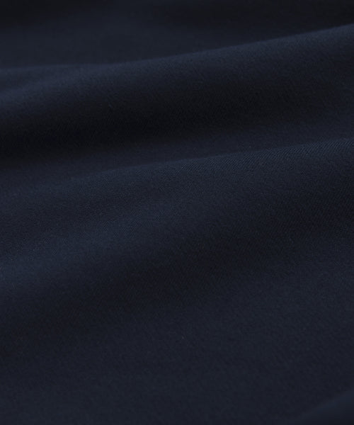 Close-up of Brushed Fleece in rich navy, highlighting the soft, smooth texture and gentle folds of the Bay Hoodie. Subtle shadows and highlights enhance the luxurious look and premium feel of this stylish hoodie.