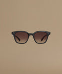 Black sunglasses with gradient lenses on a beige background