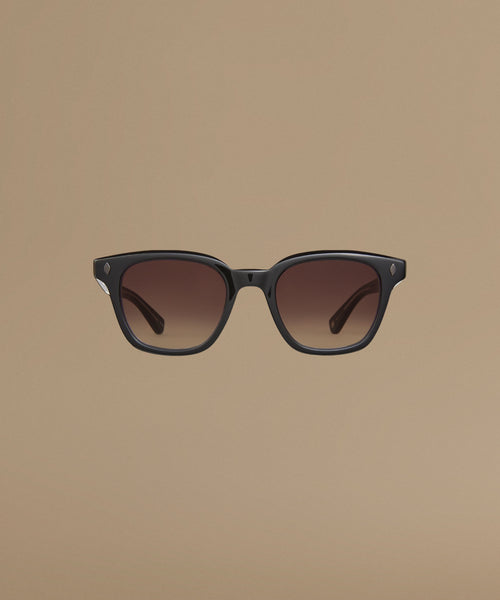 Black sunglasses with gradient lenses on a beige background