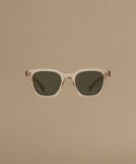 Sunglasses with a clear frame and dark lenses on a beige background