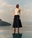 Woman standing in shallow water with a scenic background