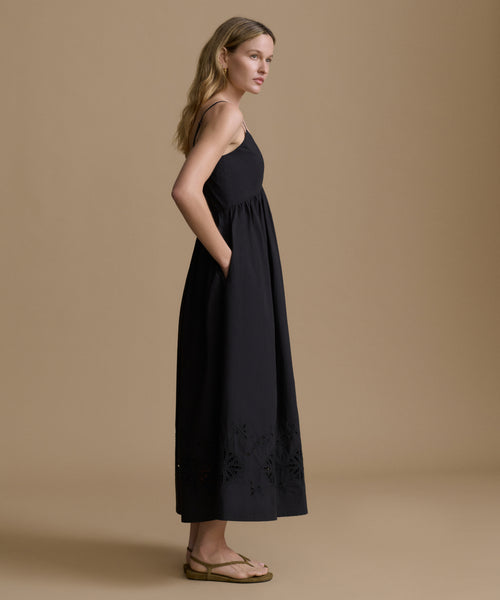 Woman wearing a black dress against a beige background