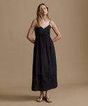 Woman wearing a black dress against a beige background