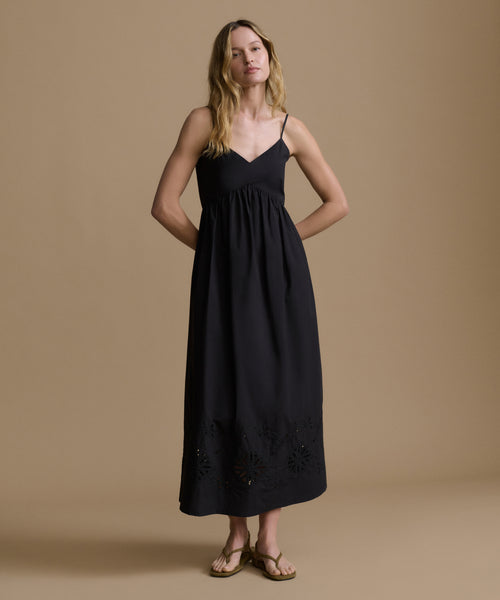 Woman wearing a black dress against a beige background