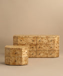 Two pieces of modern bedroom furniture are displayed: the Carbon Dresser—a light burlwood dresser with six soft-close drawers—and a smaller, hexagonal three-drawer dresser, both against a beige background.