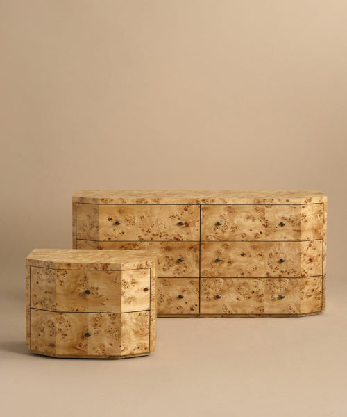 Two pieces of modern bedroom furniture are displayed: the Carbon Dresser—a light burlwood dresser with six soft-close drawers—and a smaller, hexagonal three-drawer dresser, both against a beige background.