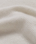 Close-up of the Cashmere Jet Turtleneck's cream-colored lightweight knit fabric, highlighting its soft texture and gentle folds—ideal for an oversized turtleneck look.