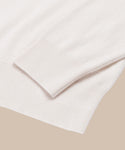 A close-up of the Cashmere Marina Crewneck in light beige, showcasing its ribbed cuff and hem against a neutral background.