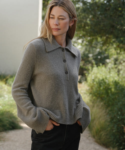 Model wearing sweater with ribbed, exaggerated collar, buttoned neck and bell sleeves.