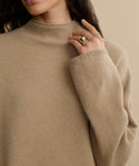 A woman wearing the Chalet Sweater, made from a soft wool-blend material.
