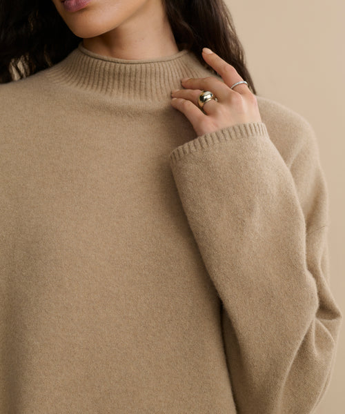 A woman wearing the Chalet Sweater, made from a soft wool-blend material.
