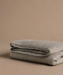 Folded gray blanket on a beige background