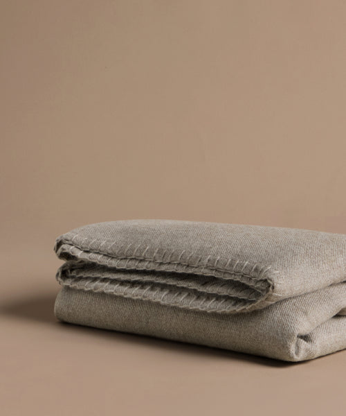 Folded gray blanket on a beige background