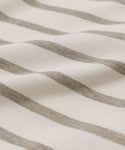 Close-up of the Claude Long-Sleeve Tee made from soft, 100% cotton fabric with horizontal beige and off-white nautical stripes, showcasing gentle folds and a smooth texture.