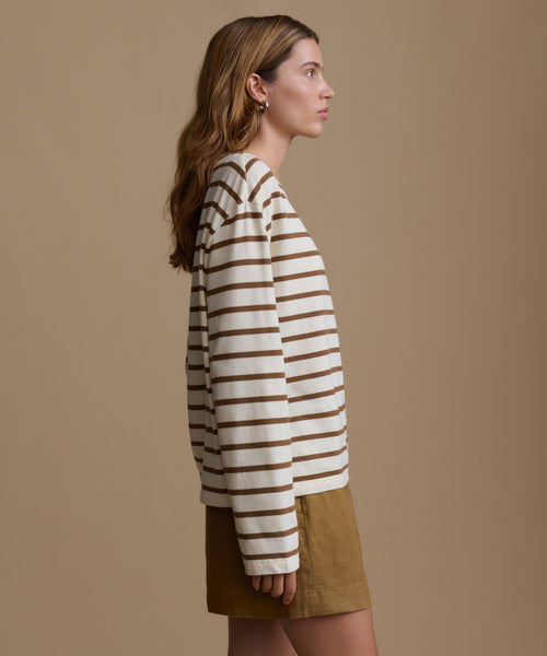 Woman wearing a striped shirt and shorts against a beige background