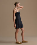 Woman wearing a black Coast Dress against a beige background