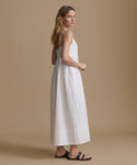 Woman wearing a white dress against a beige background