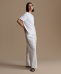 Woman wearing a white outfit against a beige background