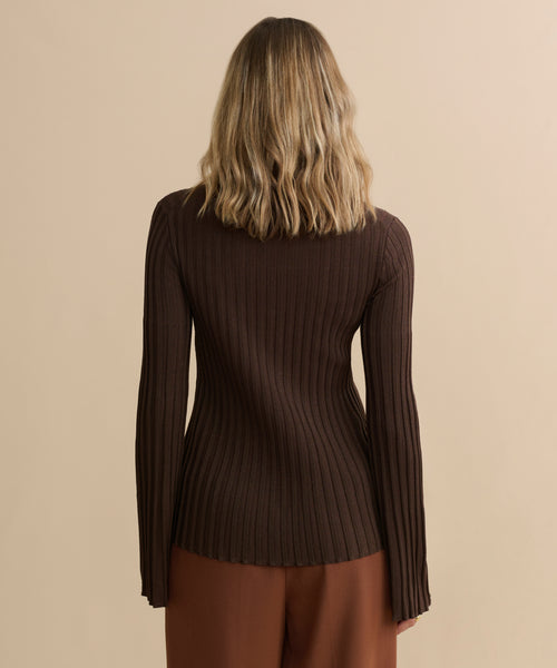 A person with shoulder-length wavy blonde hair is seen from behind, wearing the Dara Top in brown with matching brown pants against a plain beige background.