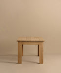 The Dining Table is a simple, handmade piece crafted from solid white oak, with a rectangular top and four straight legs. It is shown against a plain beige background.