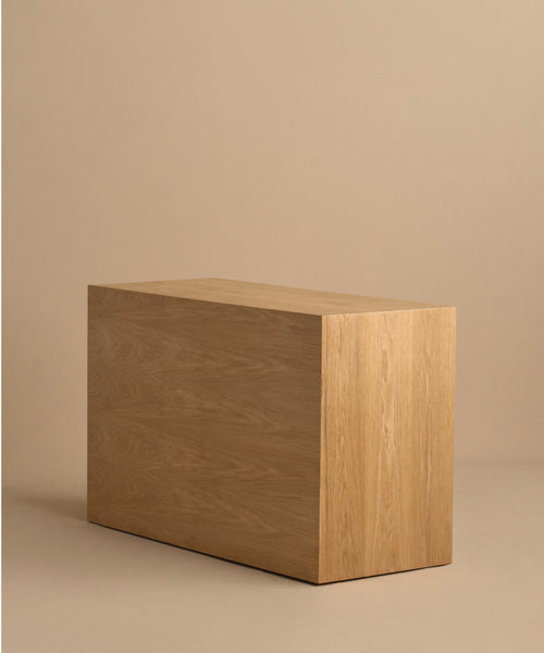 The Dune Dresser is a simple rectangular wooden piece with a smooth finish, reminiscent of White Oak furniture, displayed against a plain beige background.