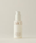 A white pump bottle labeled “Firming Plant Peptide Serum” stands upright against a plain light background; the minimal beige text highlights its powerful plant peptide formula known as a collagen booster.