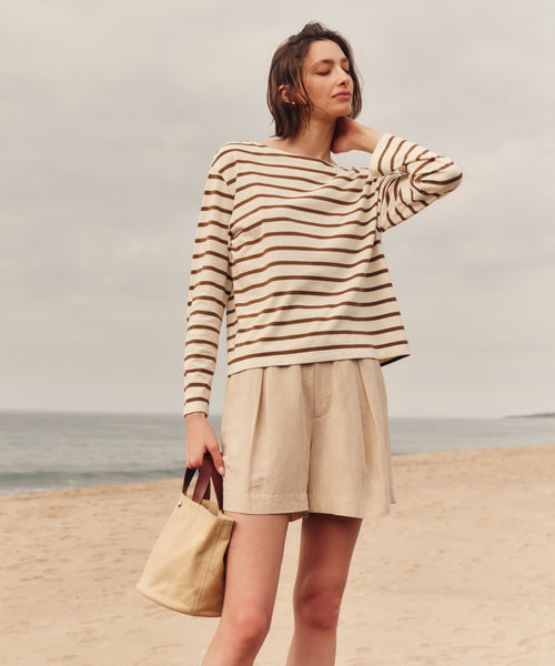 Woman wearing a striped sweater and shorts on a beach