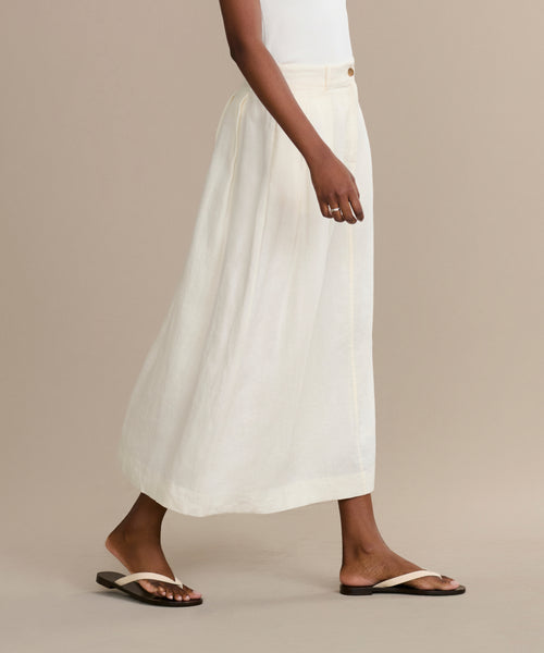 Someone is dressed in a white skirt and the Gia Sandal.