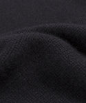 Close-up of the Grace Crewneck, a soft, deep black cashmere sweater with visible weave and gentle folds, highlighting its smooth and slightly fuzzy texture—ideal for lovers of luxury knitwear.