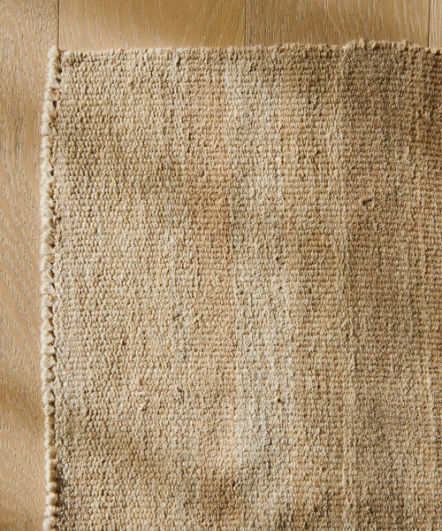 A close-up of the Handwoven Vintage Rug highlights its intricate patterns and rich fabric textures.