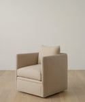 The Dume Chair is a modern, sustainable accent piece in beige hemp with clean lines, a boxy silhouette, and a single cushion. It sits on a light wood floor against an off-white wall.