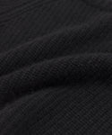 Close-up of the Kids' Cashmere Fisherman sweater in black, showing its textured fabric with visible woven patterns and soft raised ridges for a cozy, warm look.