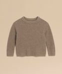 A Kids' Cashmere Fisherman sweater in beige, featuring long sleeves, ribbed knit, and a crew neckline, is laid flat on a light tan background.