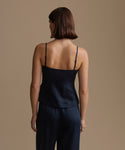 Woman wearing a navy kinney cami and pants against a beige background