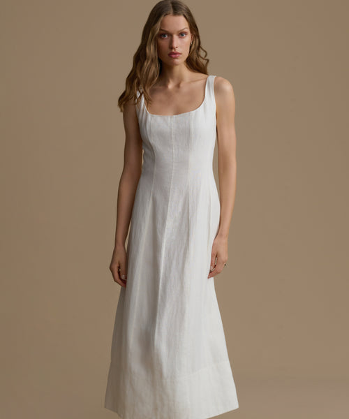 Woman wearing a white dress against a brown background