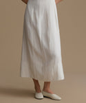 Person wearing a white dress with a plain background