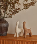 A pair of Knit Llamas on a shelf—ideal as a cuddly companion or playful decor.